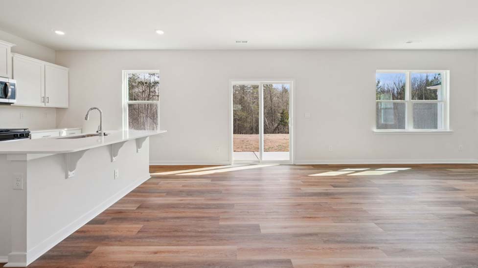 Family room with large windows and fireplace, beside kitchen
