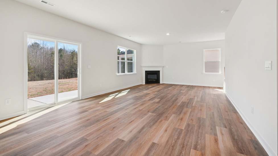 Family room with large windows and fireplace, beside kitchen