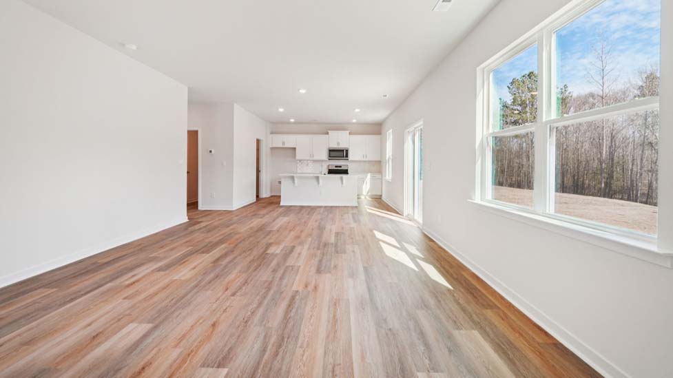 Family room with large windows and fireplace, beside kitchen