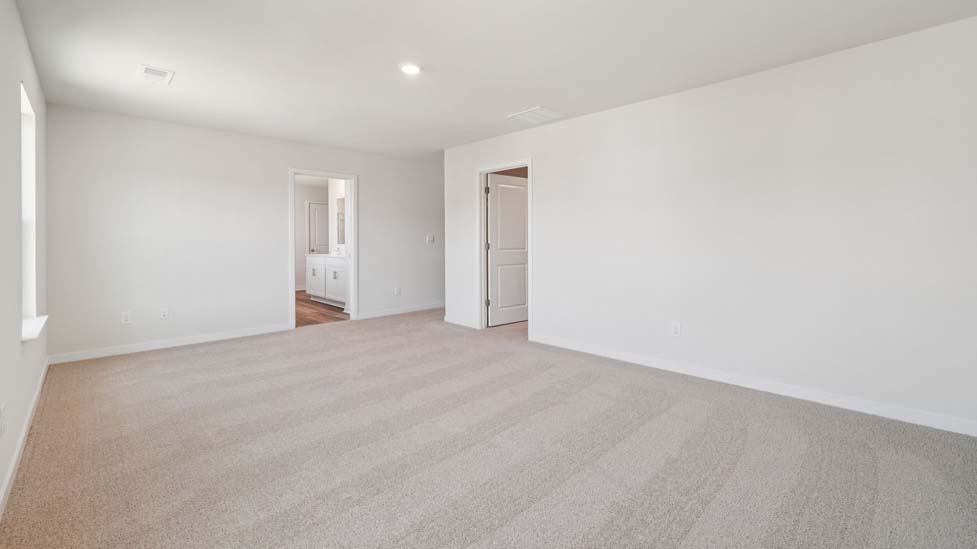 Primary bedroom with carpet and large windows