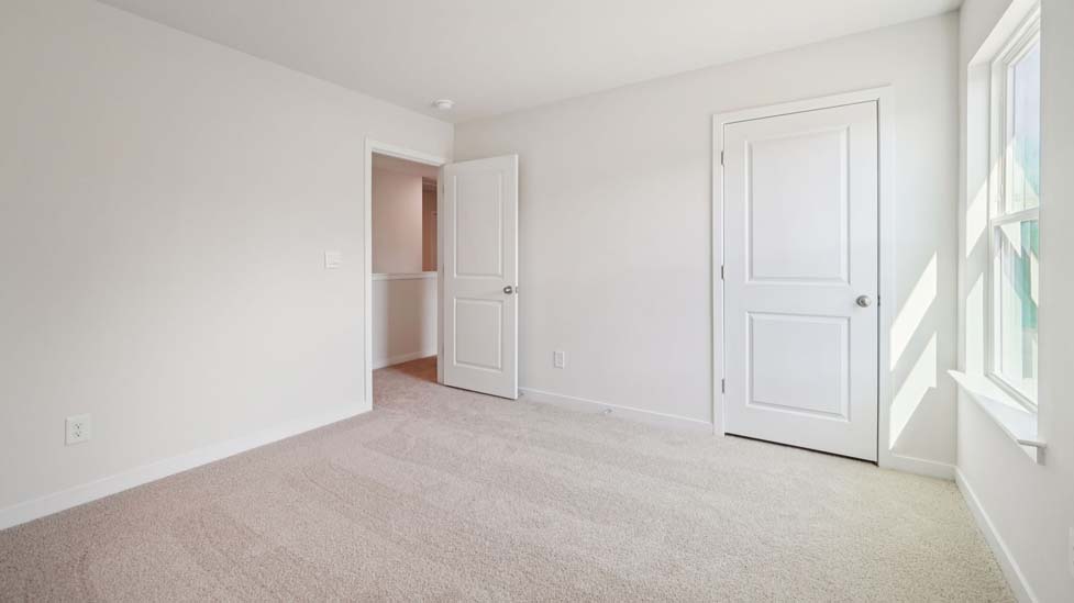 Carpeted bedroom with large window