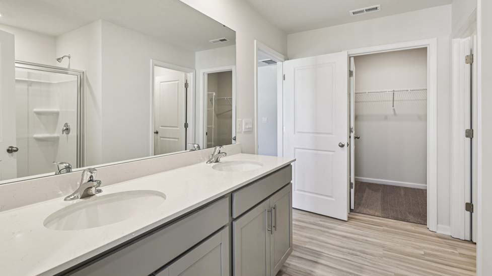 Primary bathroom with standing glass shower and double sinks