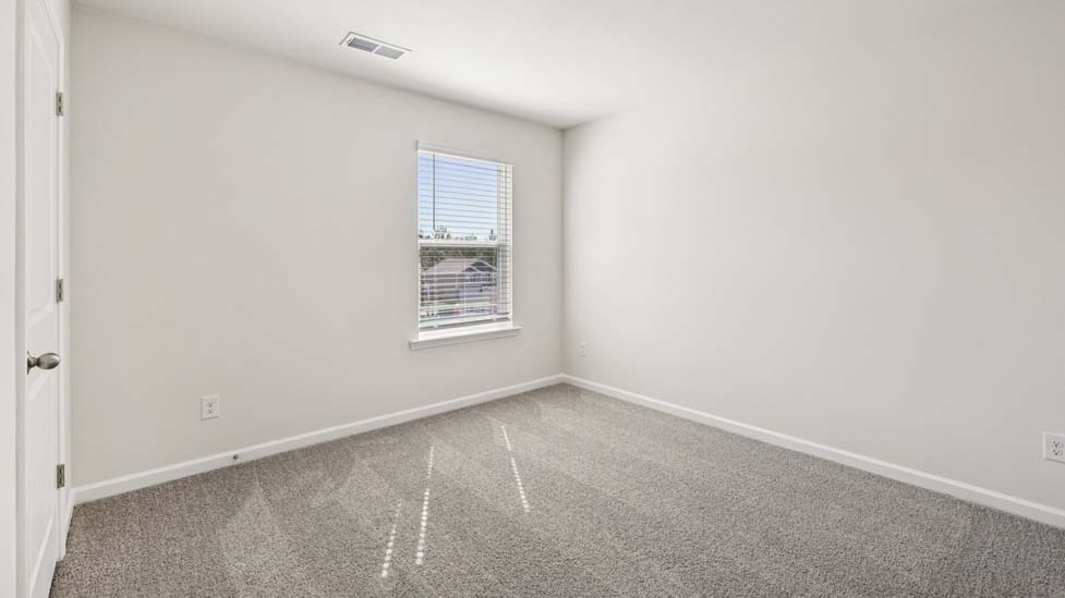 Carpeted bedroom with windows