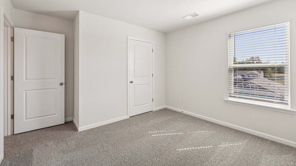 Carpeted bedroom with windows