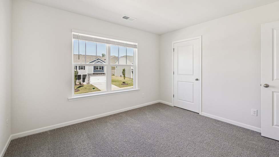 Carpeted bedroom with windows