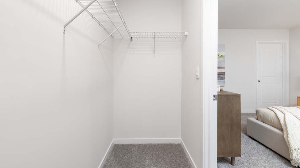 Carpeted walk in closet with racks