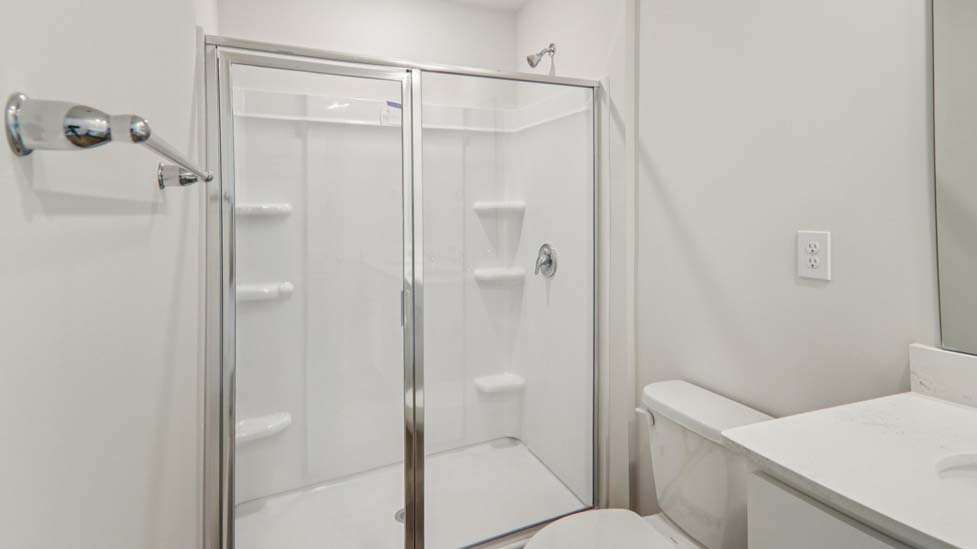 bathroom with white cabinets and standing glass shower