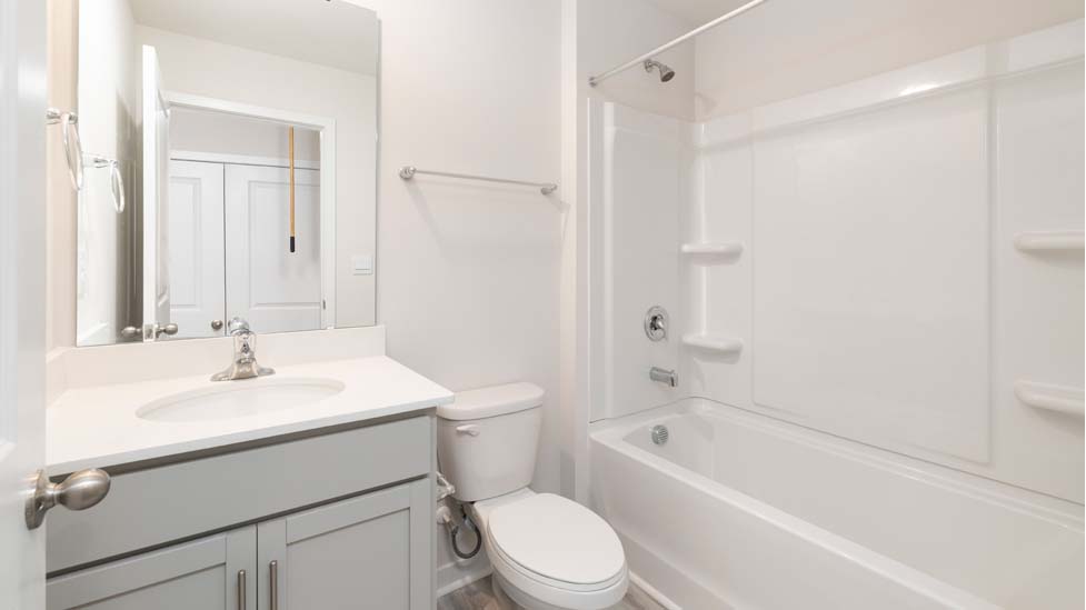 bathroom with white cabinets and standing glass shower