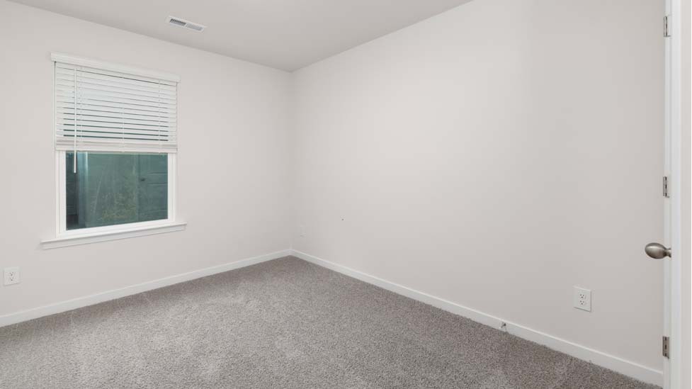 Carpeted bedroom with large window
