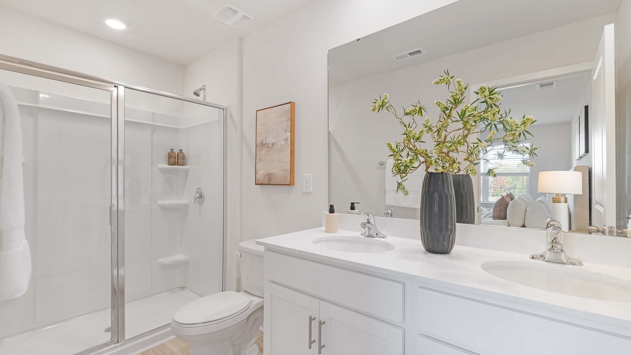 primary bathroom with standing shower and double sink vanity