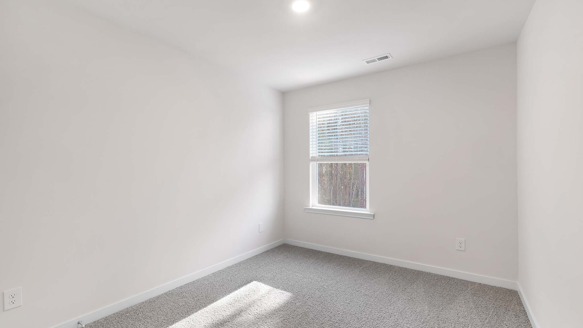 carpeted bedroom with small window