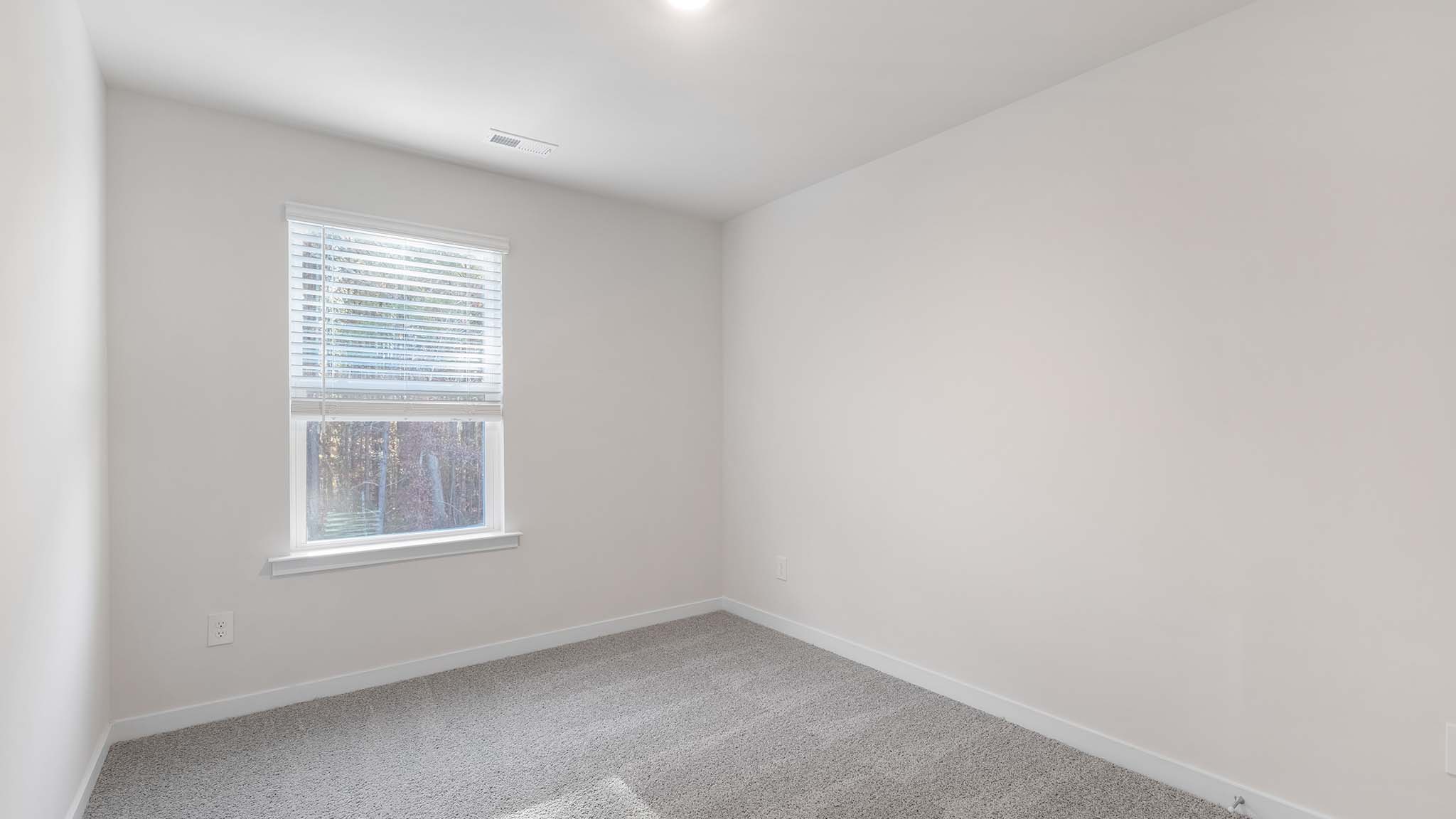 carpeted bedroom with small window