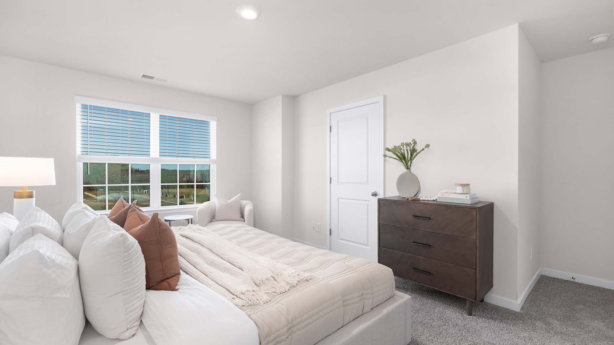 primary bedroom with carpet and large window