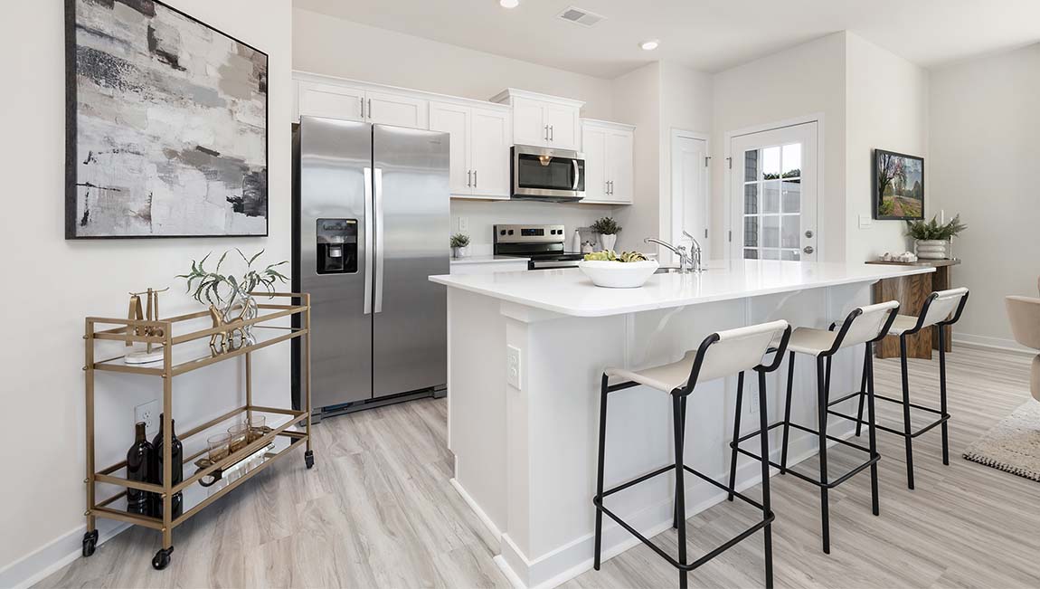 Kitchen and island with white cabinets, subway tile backsplash, and stainless steel appliances
