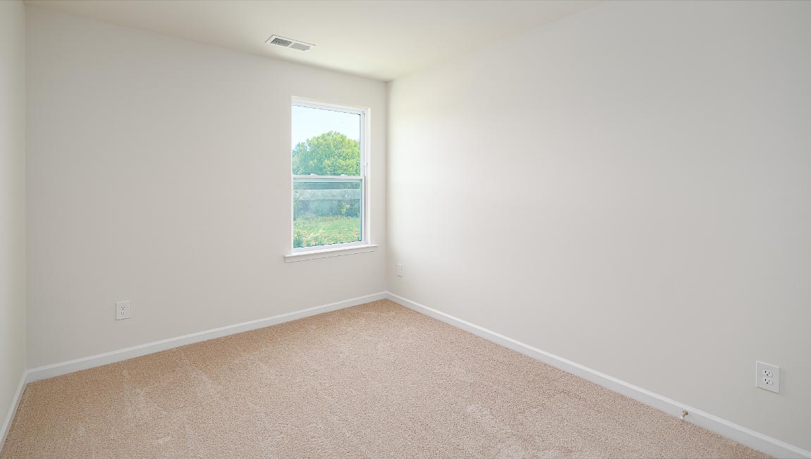 Carpeted bedroom with small window
