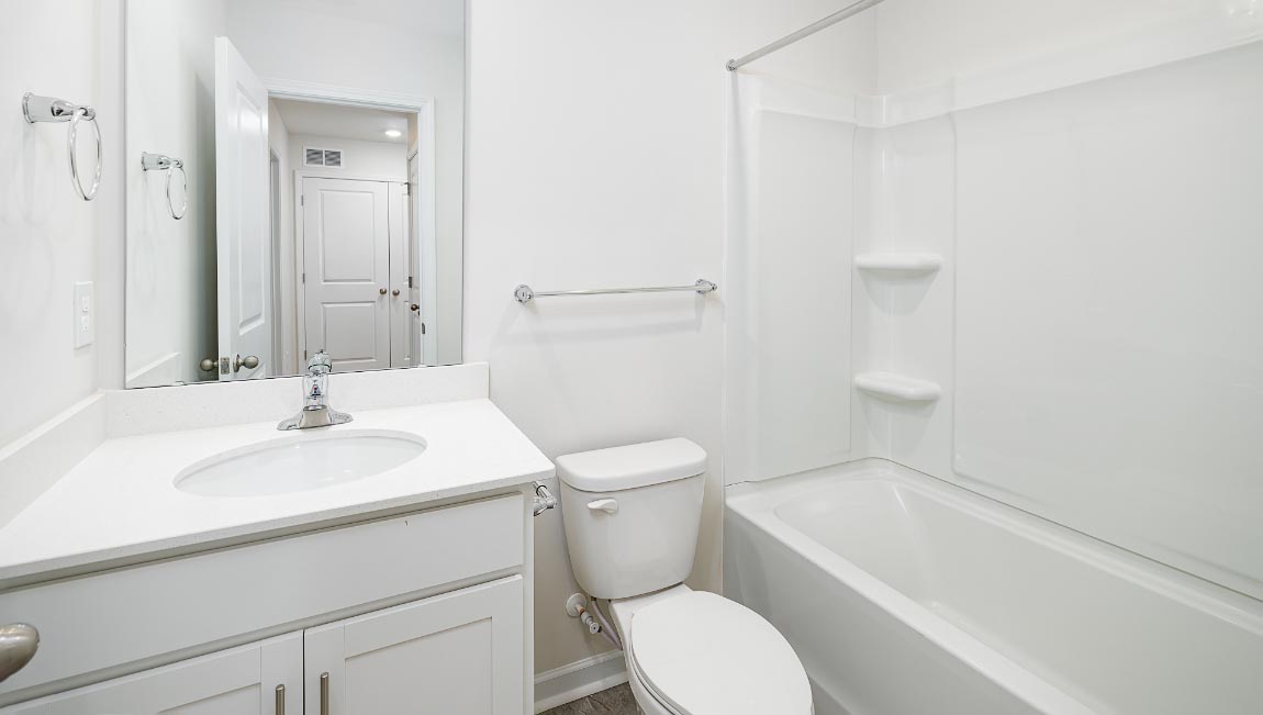 Bathroom with bathtub, white cabinets and counters