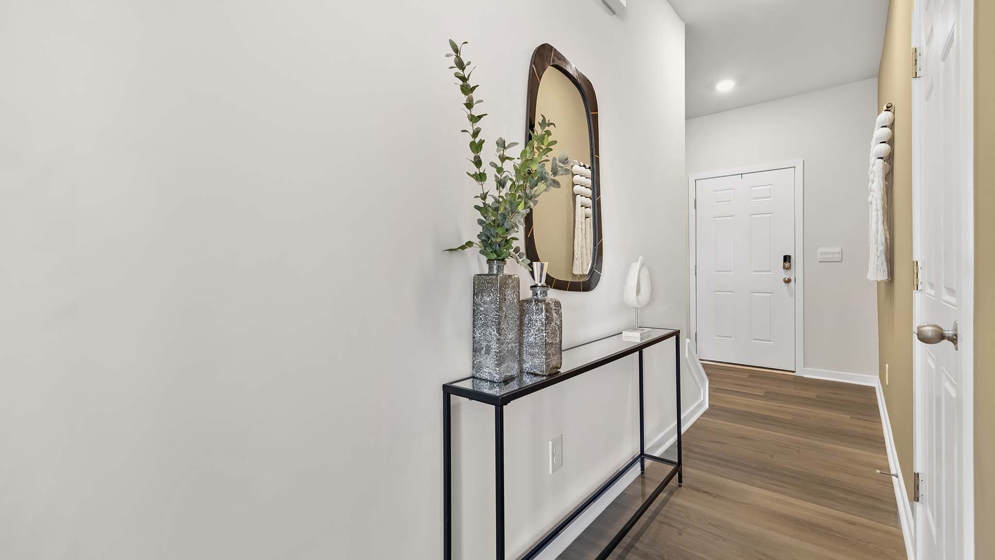 welcoming foyer with wood floors, and white walls