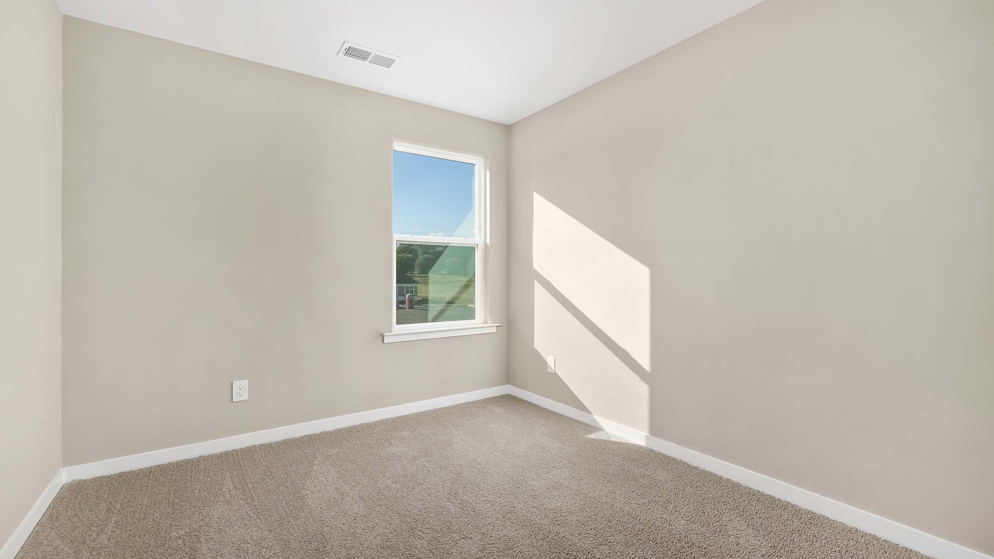 carpeted bedroom with small window