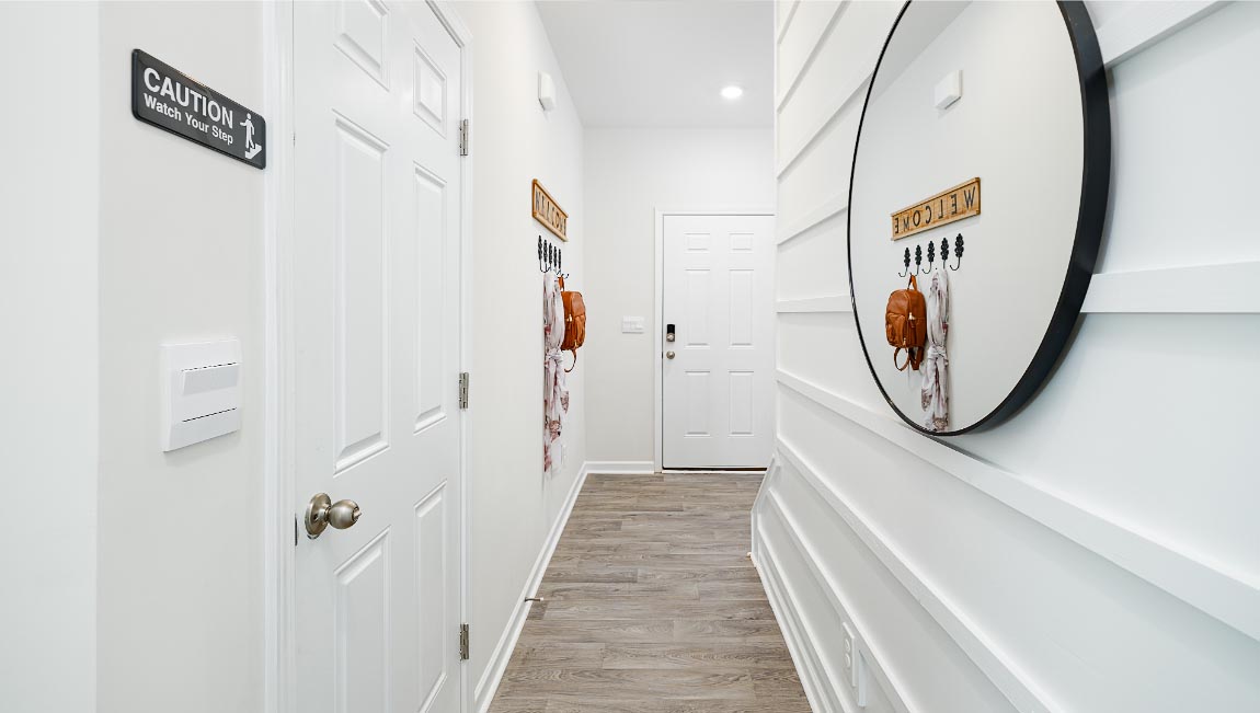 welcoming foyer with wood floors, and white walls