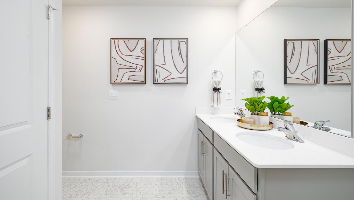 primary bathroom with double sinks, grey cabinets, and white counter