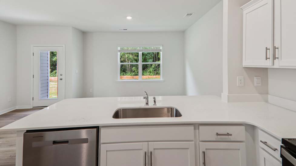 Kitchen and island with white cabinets and stainless steel appliances