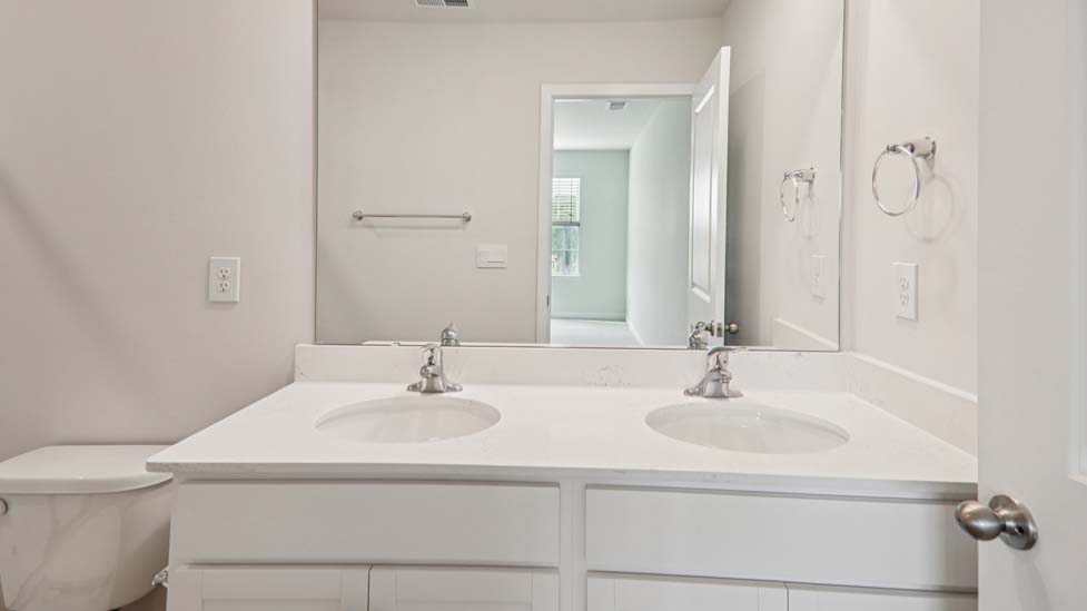 Primary bathroom with double sink vanity and standing shower