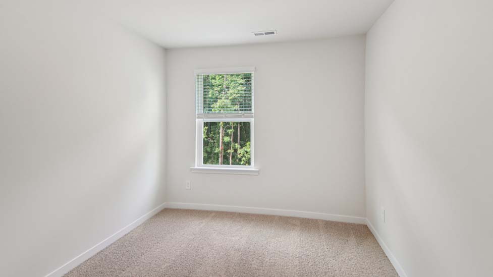Carpeted bedroom with small window