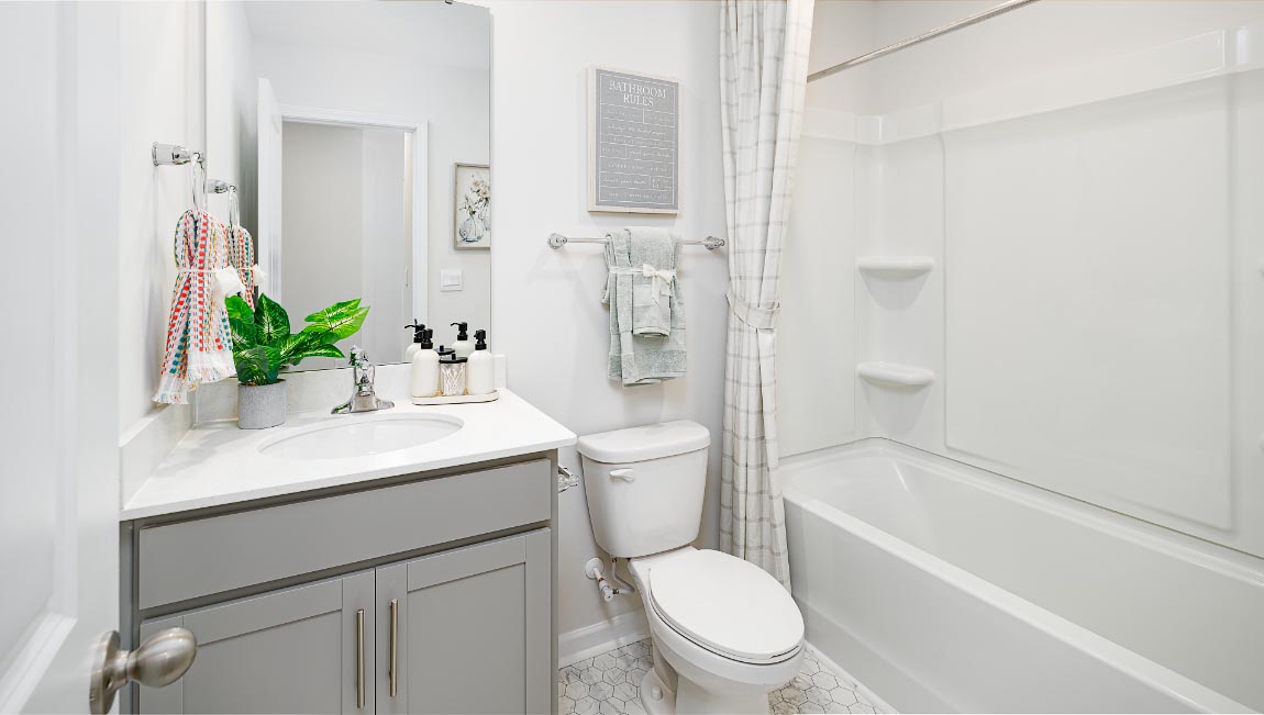 primary bathroom with double sinks, grey cabinets, and white counter