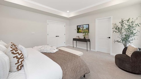 Primary bedroom with carpet, sitting space, and large window