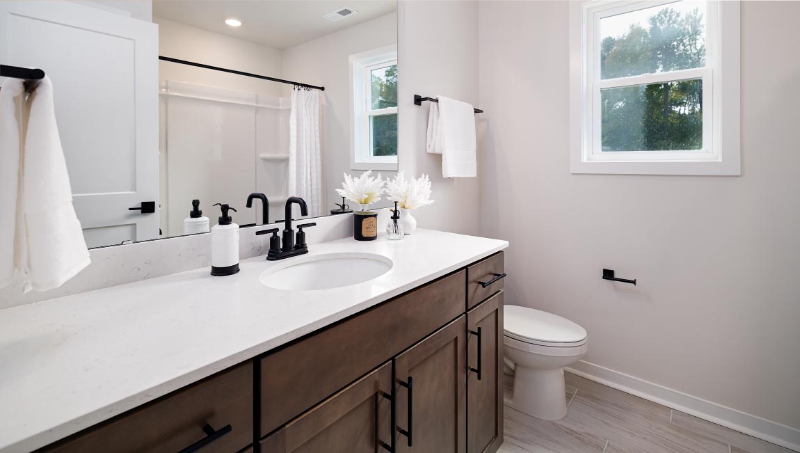 Primary bathroom with double sinks and standing glass shower with tub