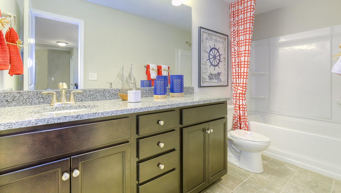 Bathroom with brown cabinets and bathtub