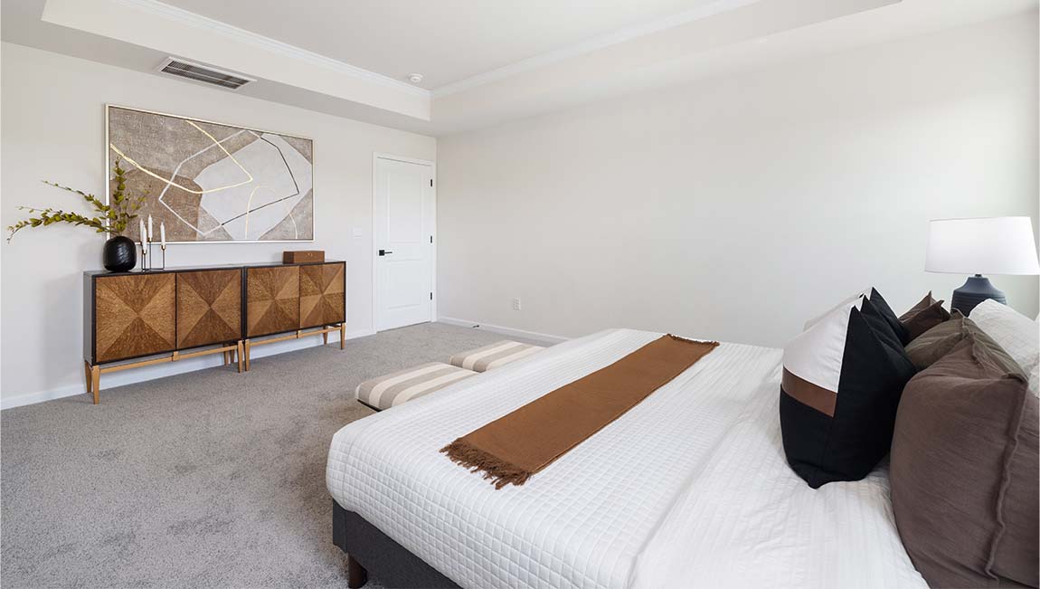 Primary bedroom with carpet and two large windows