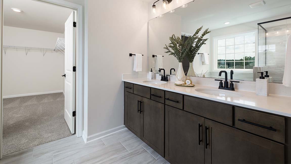 Bathroom with double sinks, white cabinets and counters