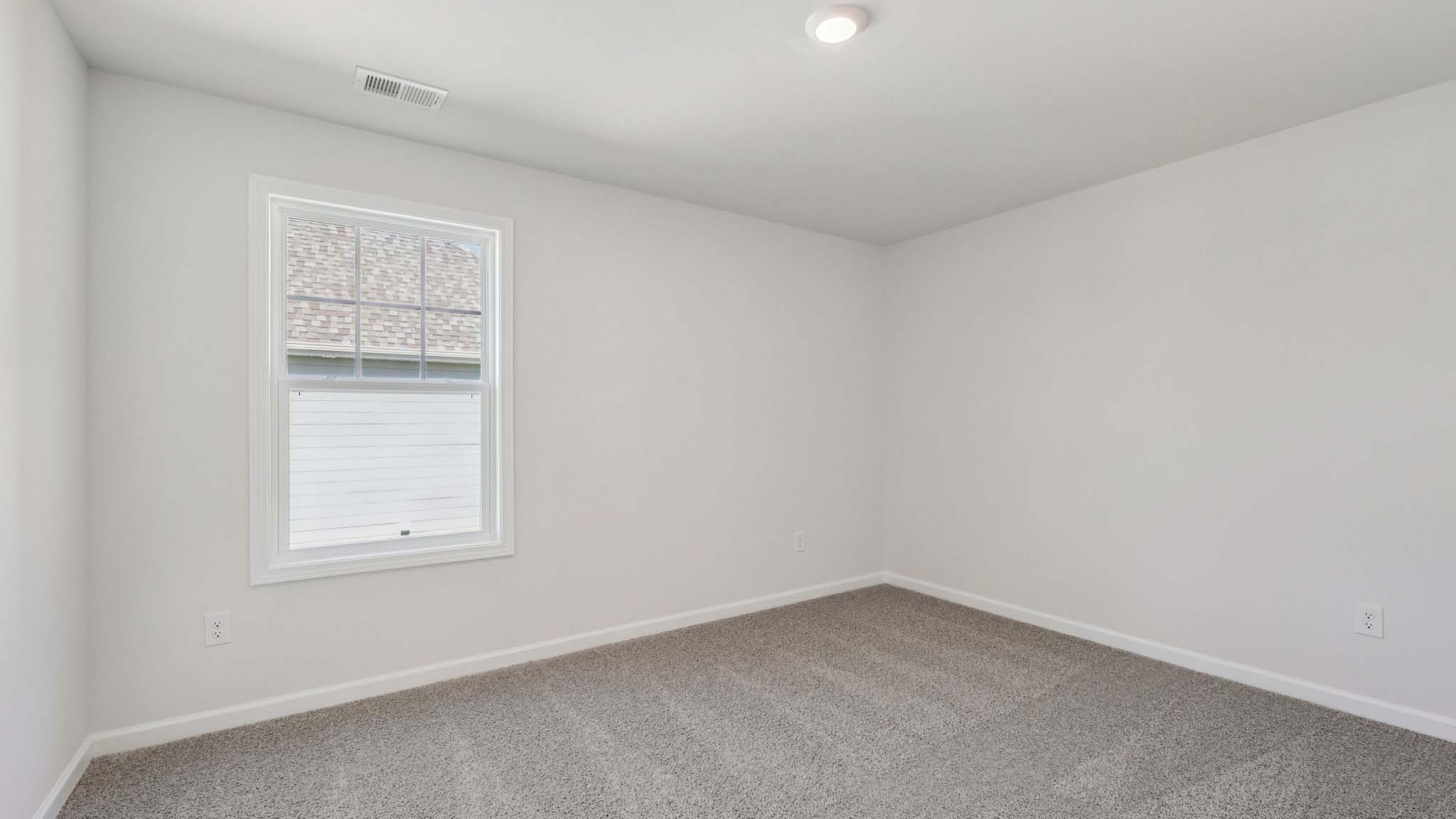 Carpeted bedroom with large window
