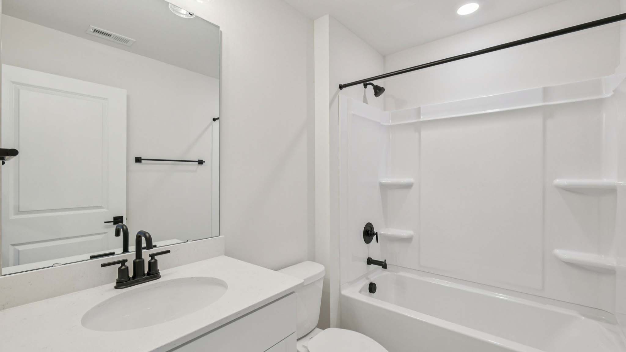 Bathroom with double sinks, white cabinets and counters