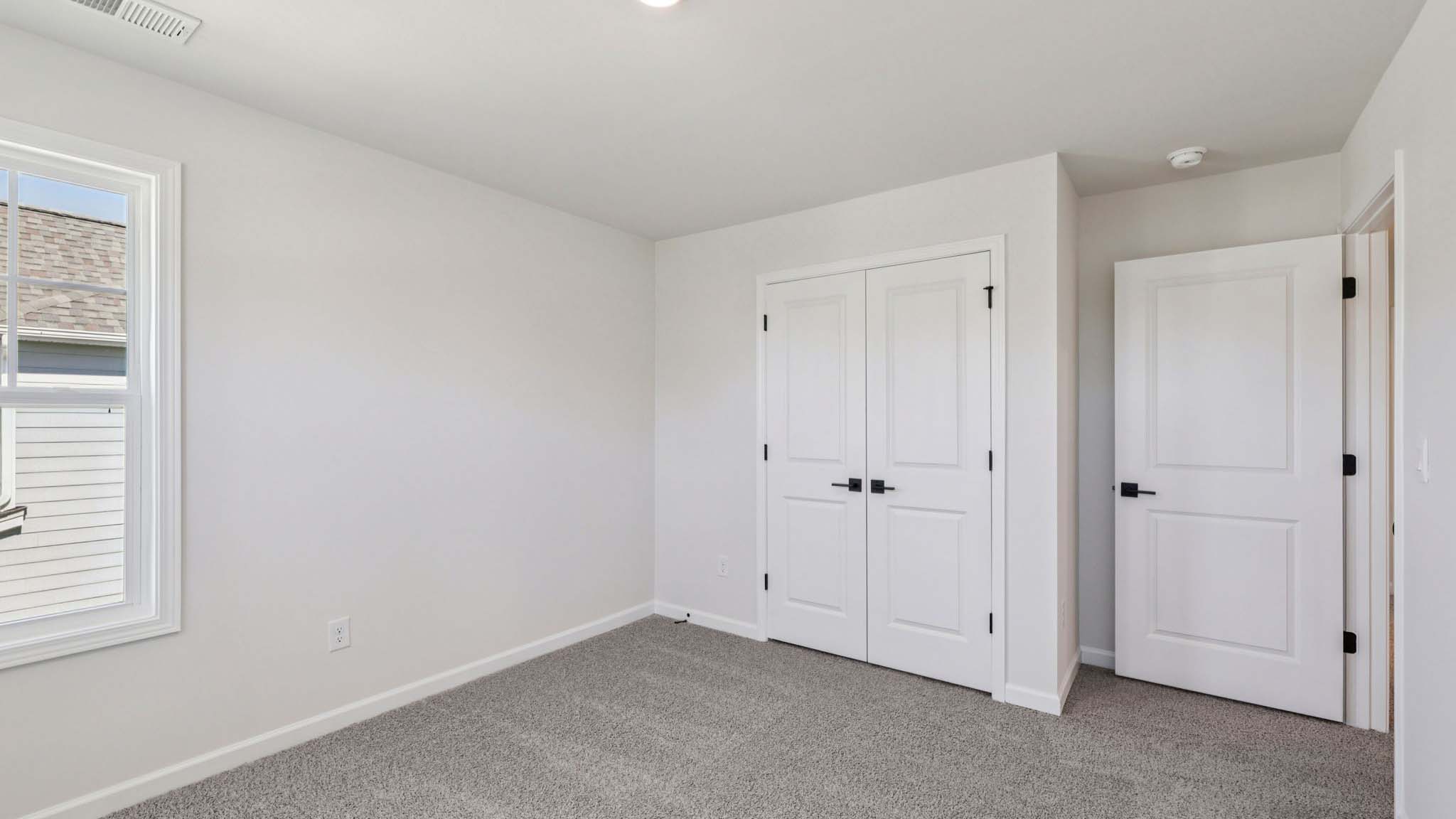 Carpeted bedroom with large window