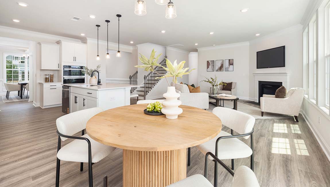 Kitchen and island with white cabinets and counters, wood floors, and stainless steel appliances
