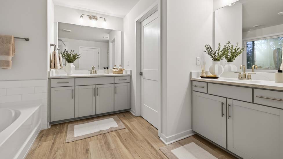 Primary bathroom with grey cabinets and standing glass shower
