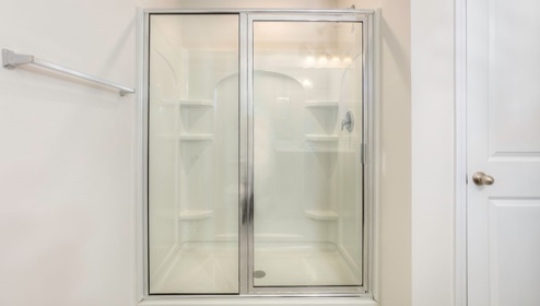 primary suite bathroom with glass door shower