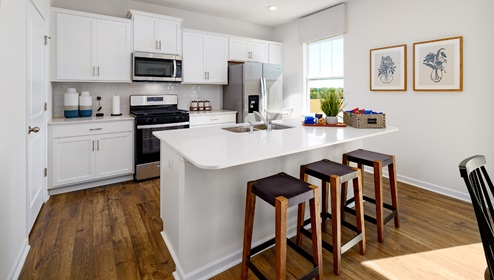 Kitchen and island, with white counters and cabinets