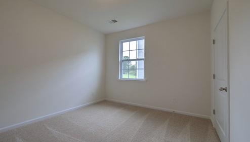 Carpeted bedroom with small window