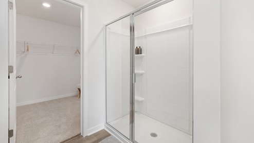primary bathroom with standing glass door shower and attached walk in closet. new homes in charlotte, nc