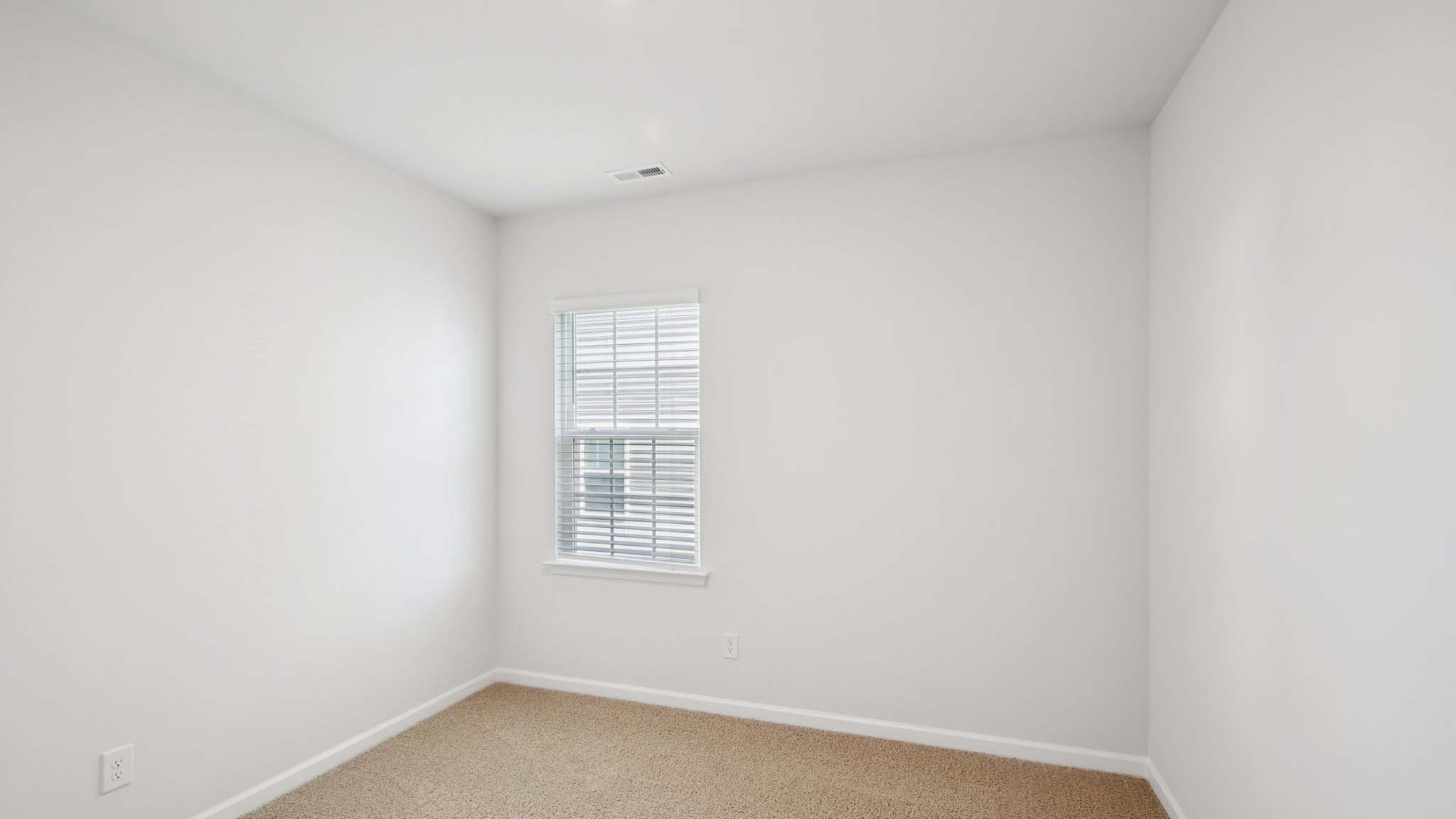 Carpeted bedroom with large window