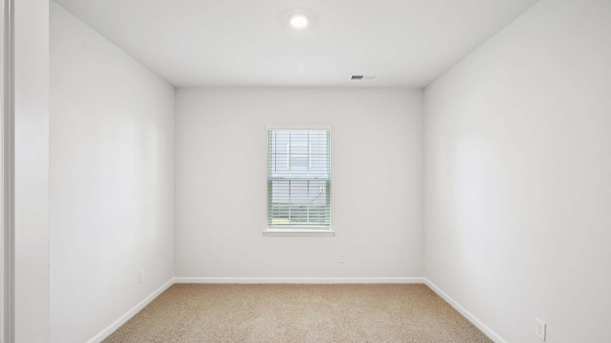 Carpeted bedroom with large window