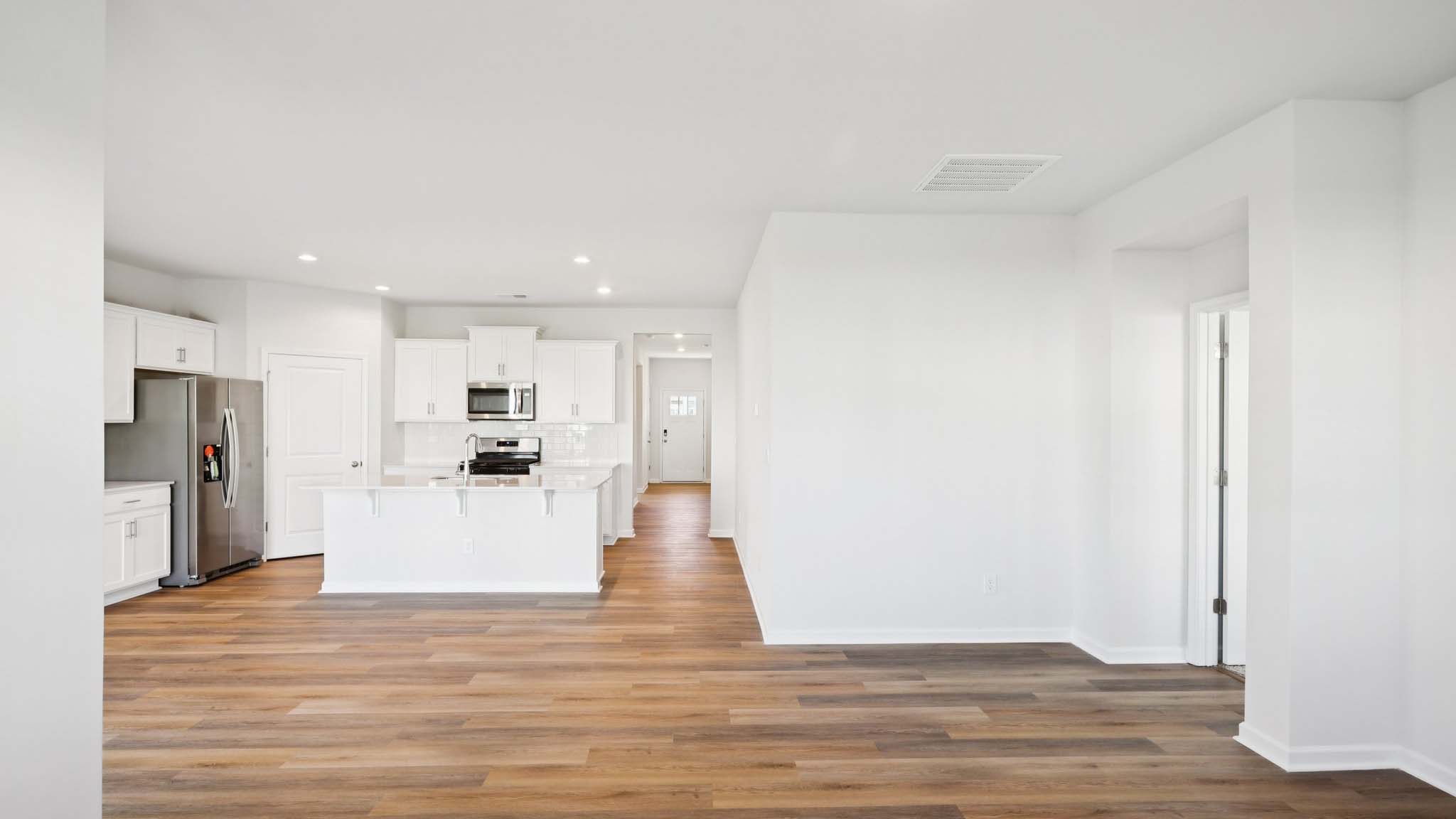 Open living room with wood floors, large window, and fireplace