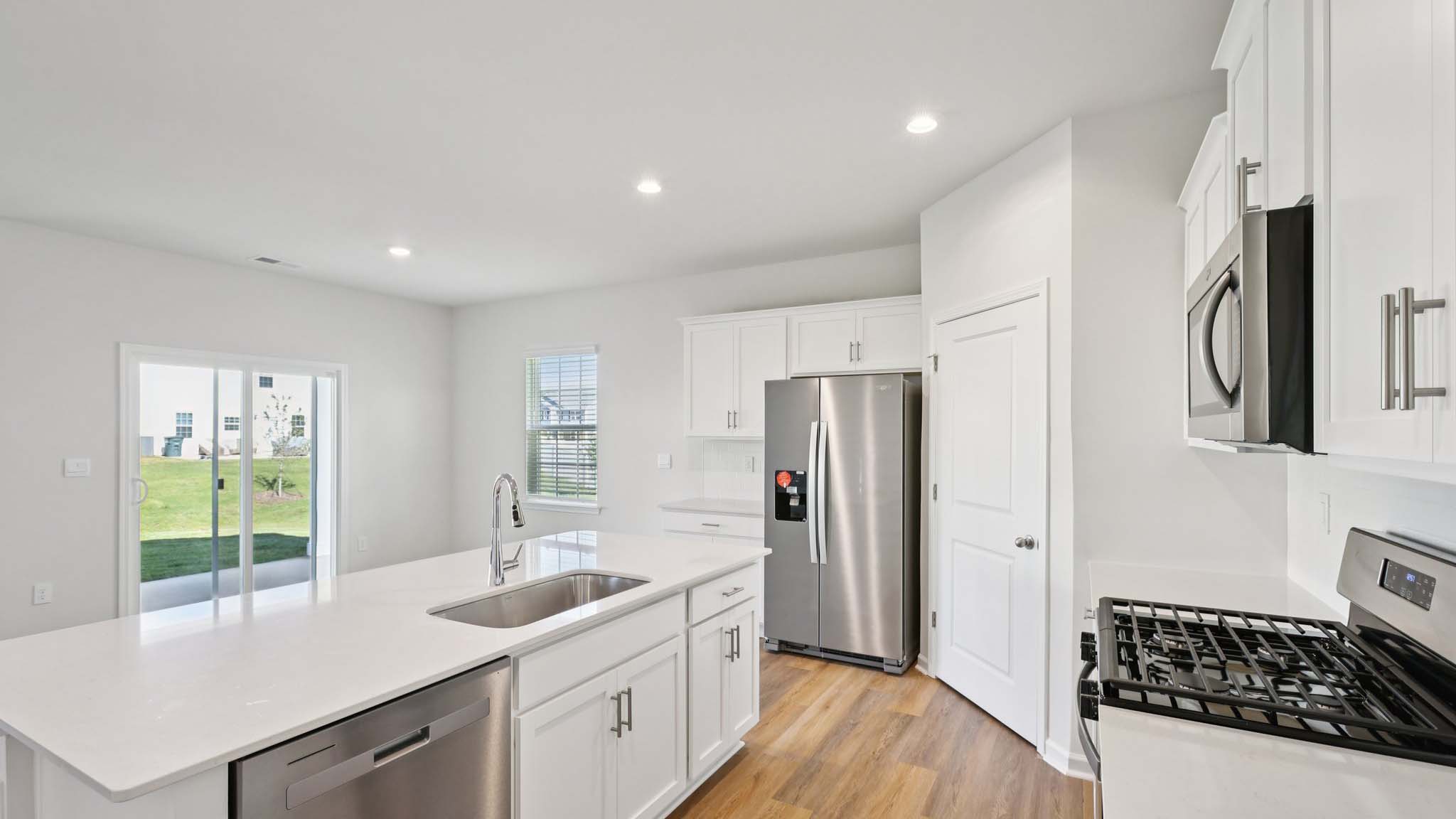 Kitchen and island with white cabinets and subway tiles and stainless steel subway tiles