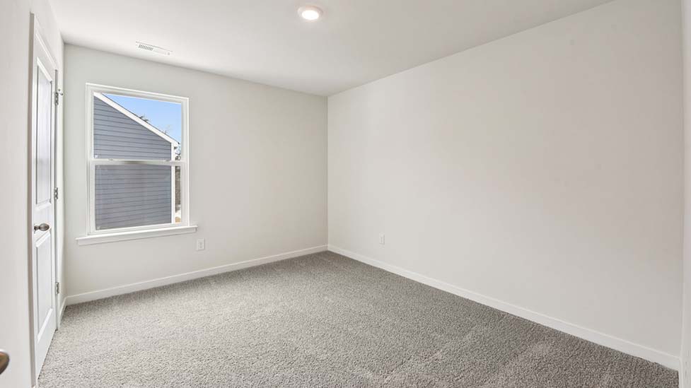 Carpeted bedroom with large window