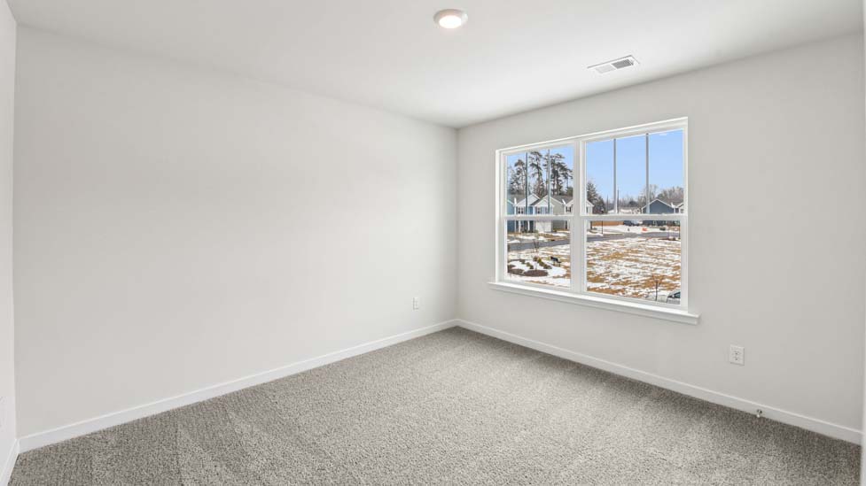 Carpeted bedroom with large window