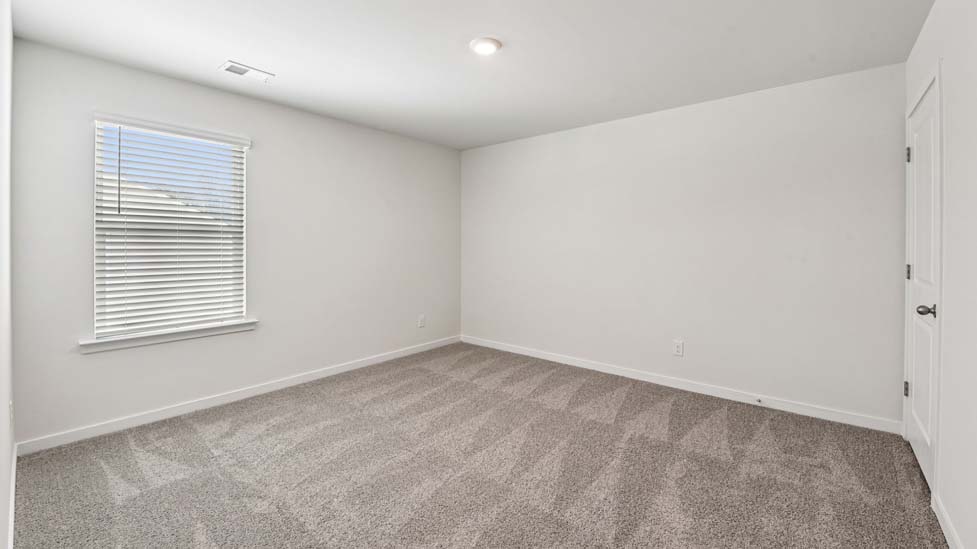 Carpeted bedroom with large windows