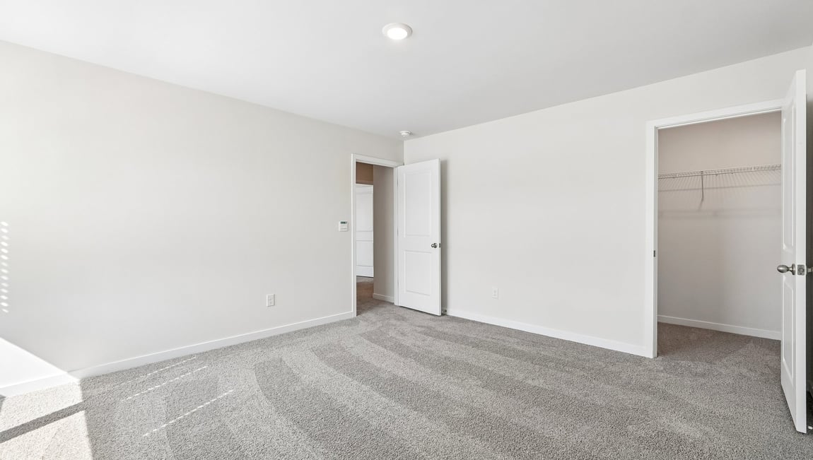 carpeted bedroom with windows